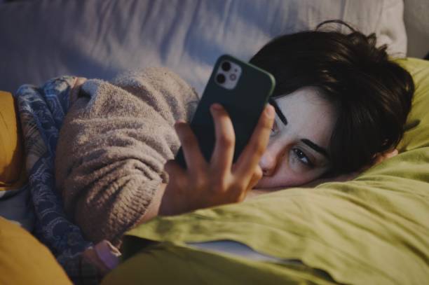 Person browsing their phone in bed, discovering personalized gift ideas and digital invitations with Airawath’s AI.